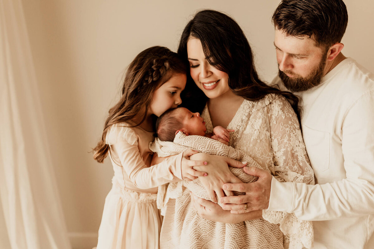 Family portarit of a mother, father, sibling, and a baby boy.