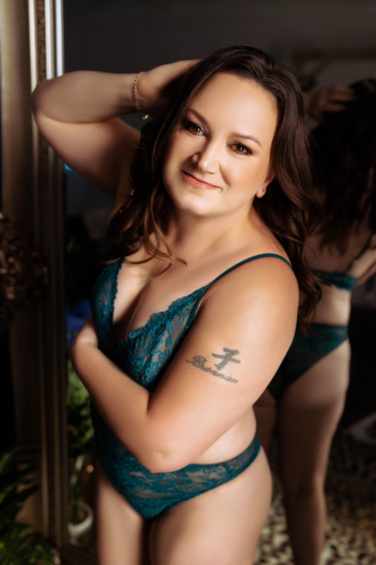 close up portrait of woman in blue lingerie leaning against mirror with tattoo during boudoir session elkridge