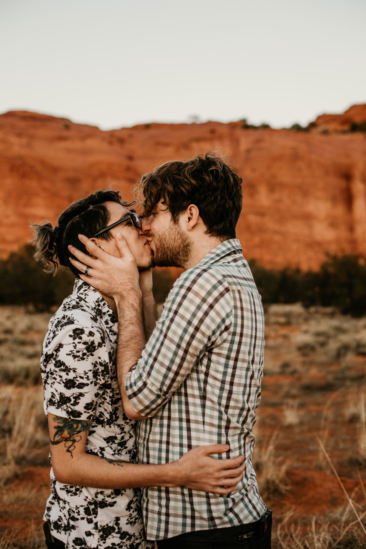 two men kissing in the desert