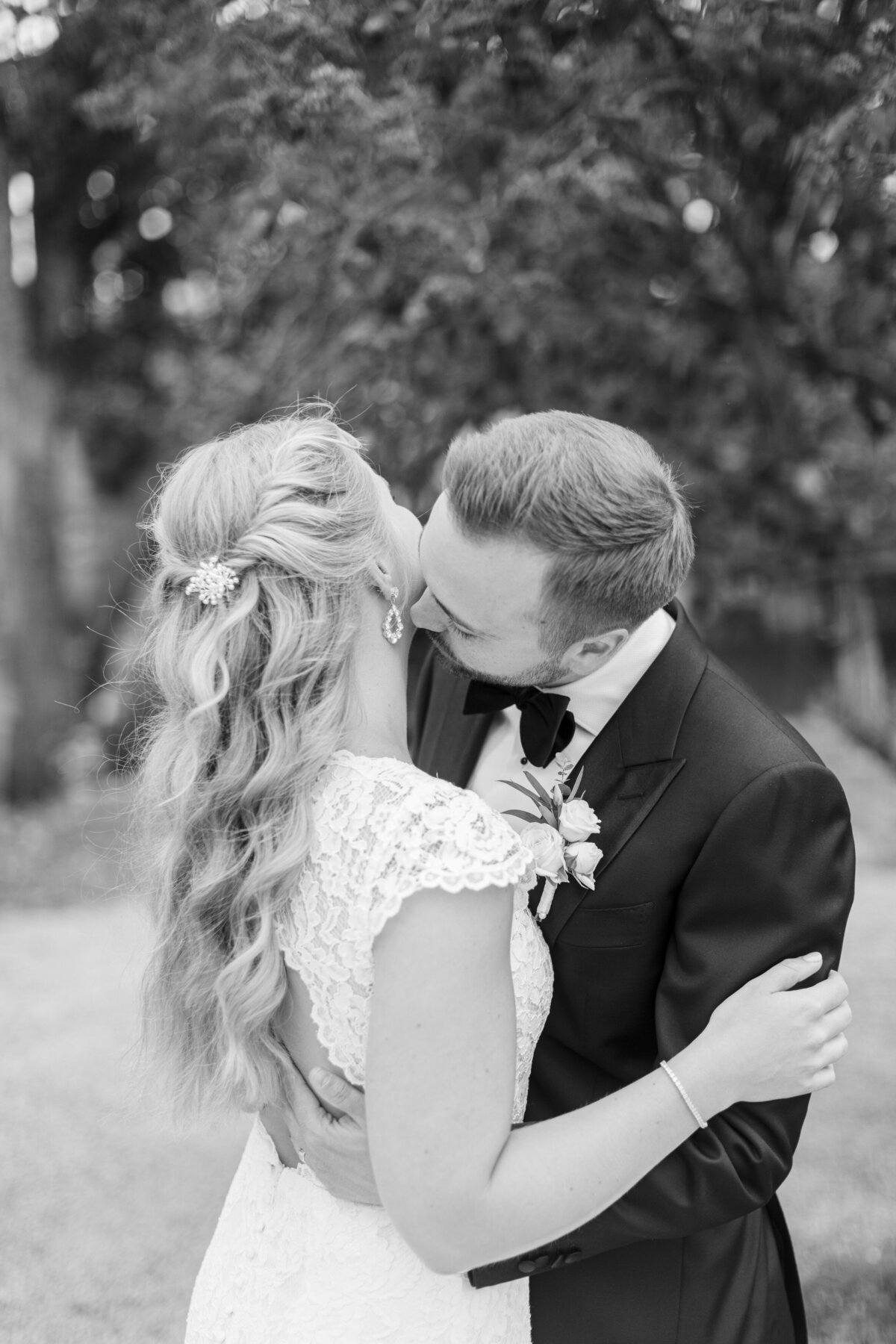Brudgum kysser bruden på halsen vid Schenströmska