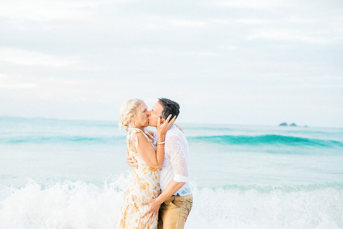 husband and wife kissing in ocean