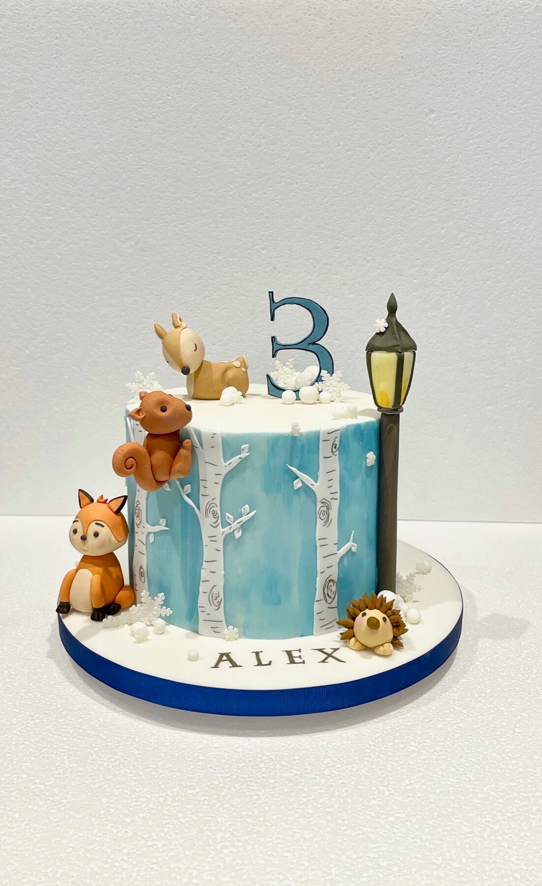 A cute birthday cake with a fox, deer, hedgehog and squirrel