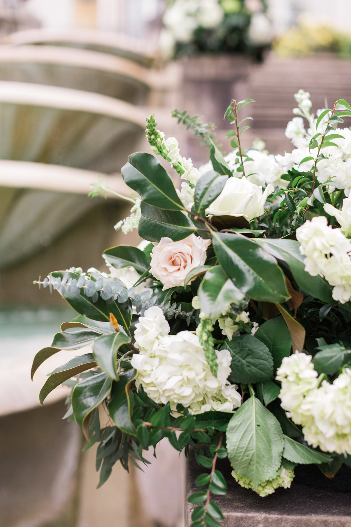 Soft neutral flowers compliment the water feature at this luxury Swan House wedding. Photo by luxury destination wedding photographer Rebecca Cerasani.