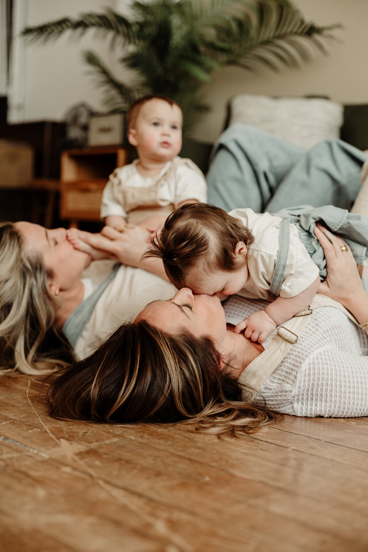 Moms kissing their twin girls