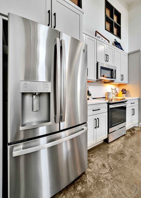 Stainless steel fridge in this industrial two-bedroom, two-bathroom first floor rental condo in the historic Behrens Building in downtown Waco, TX.