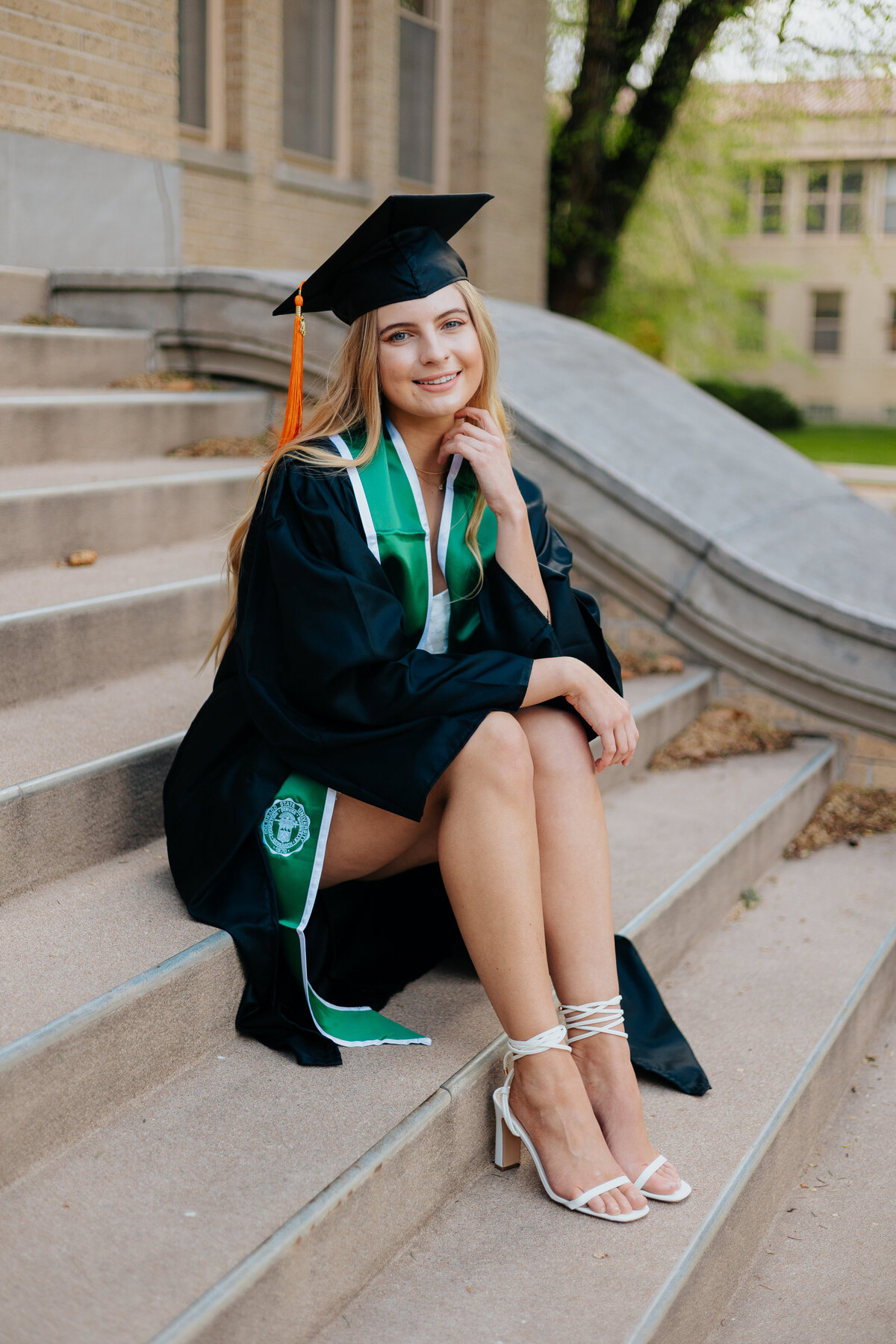Sitting on the steps of the Administration Building at Colorado State University, a graduate poses during her senior grad session.