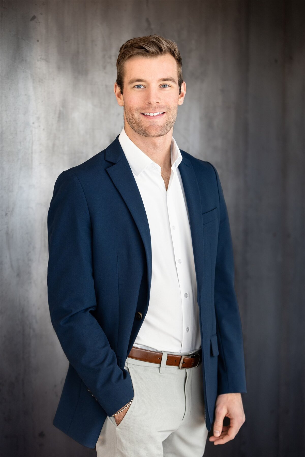 Man in navy blazer poses for headshot photo in Denver