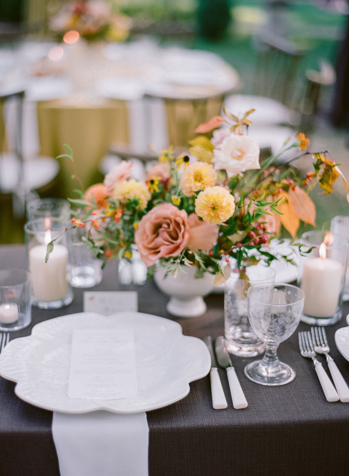 Lush fall florals for low and high centerpieces at fall wedding reception. Clear tented wedding reception in the family's back yard creating an intimate wedding reception environment. Whimsical and organic floral design in colors of copper, yellow, blush,and brown. Fall florals with sweet peas, dahlias, butterfly ranunculus, roses, mums, and bittersweet berries. Design by Rosemary & Finch Floral Design in Nashville, TN.