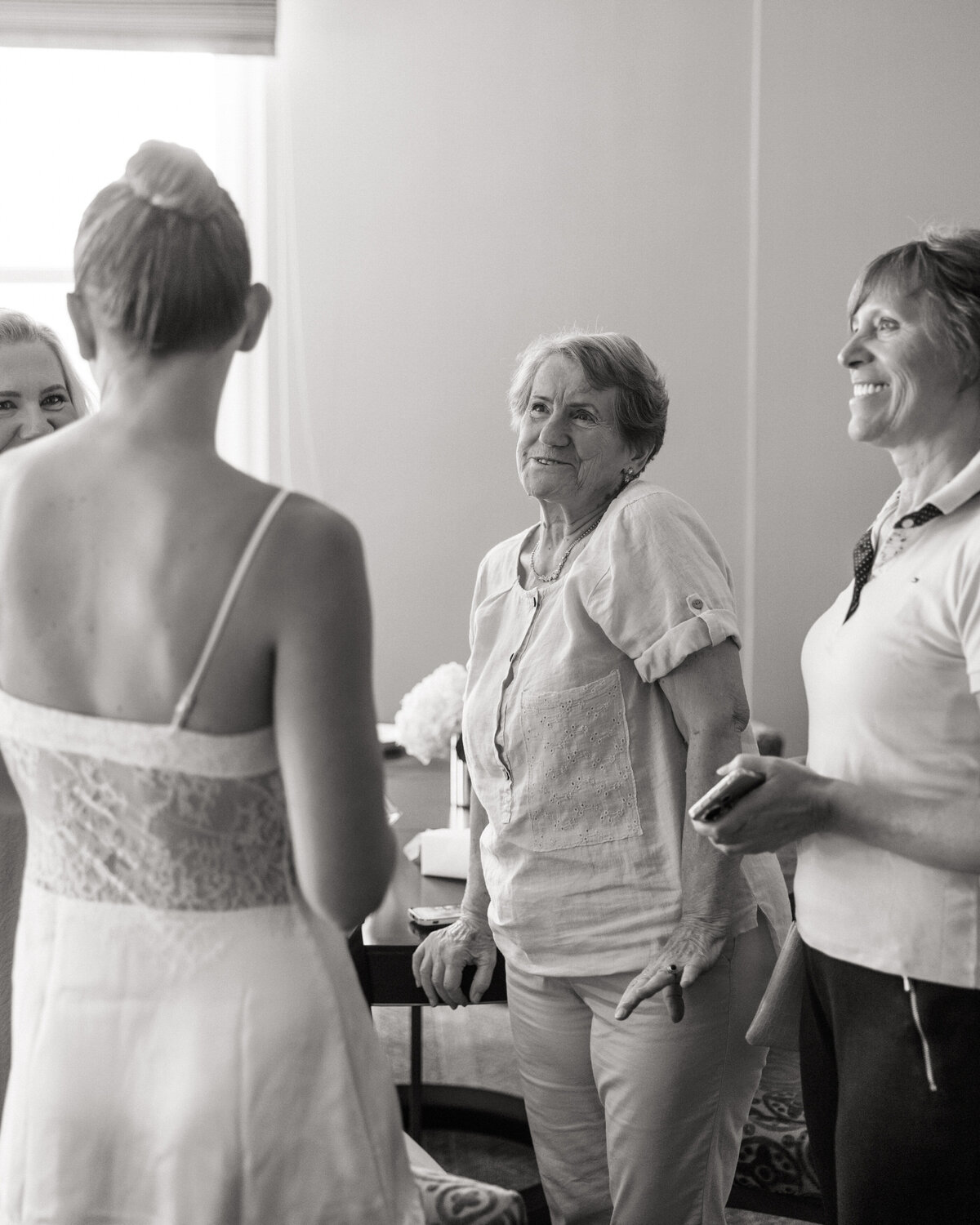Black-and-white candid of bride chatting with family during prep, photographed in Philadelphia.