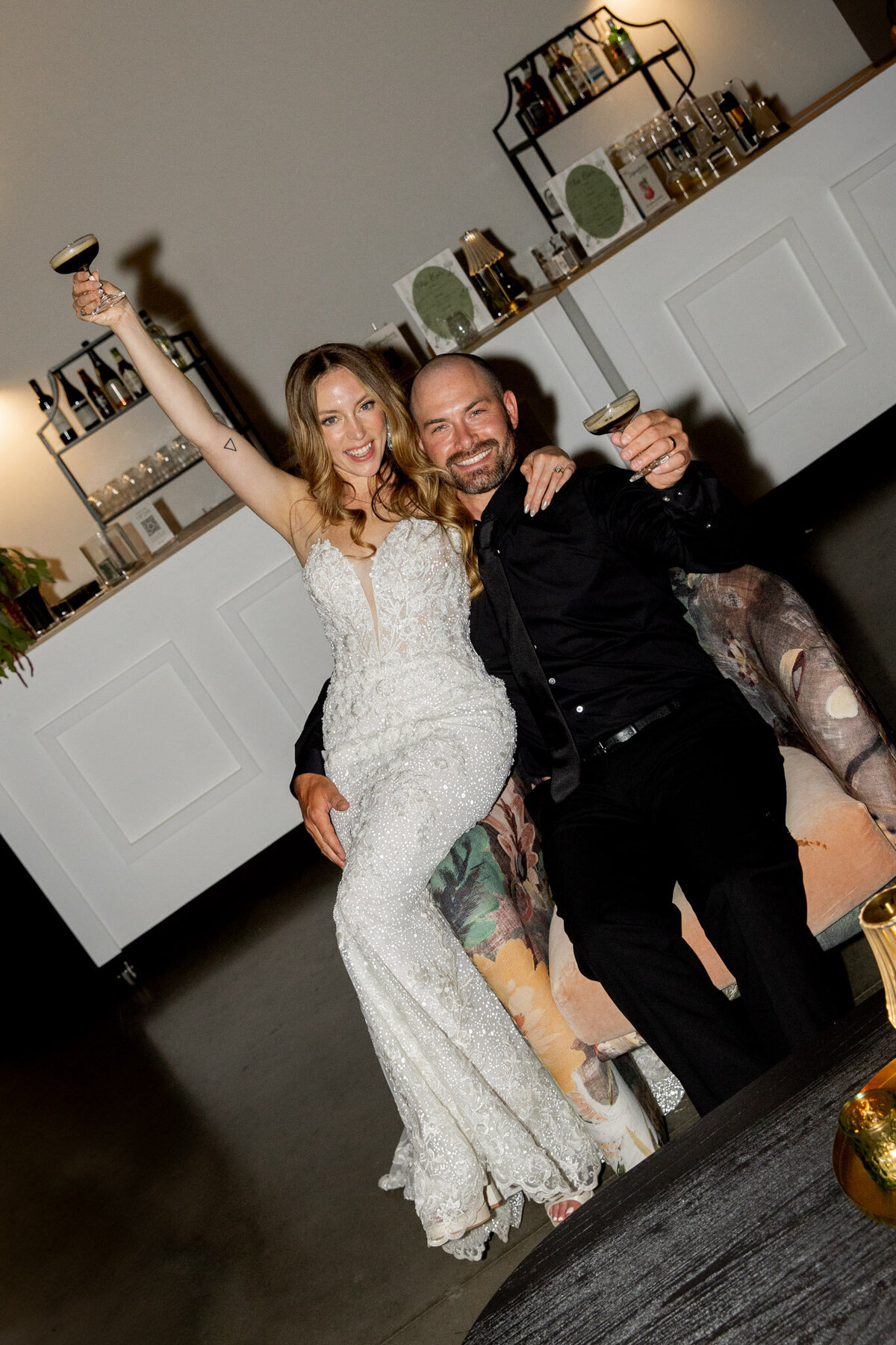 Husband and wife drinking espresso martinis during their reception in Raleigh, NC. The photo is editorial.