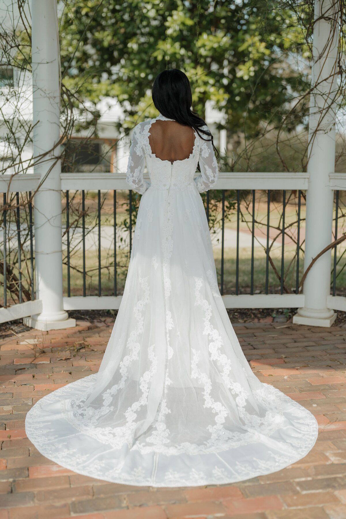 Bride showing off her dress under a canopy