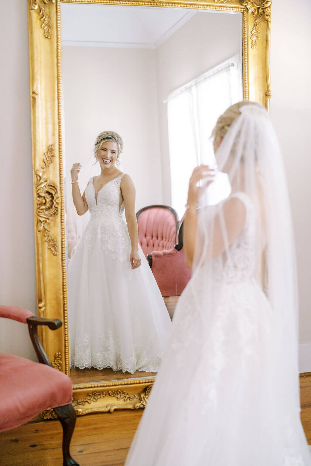 bride looking at herself in mirror during getting ready portraits