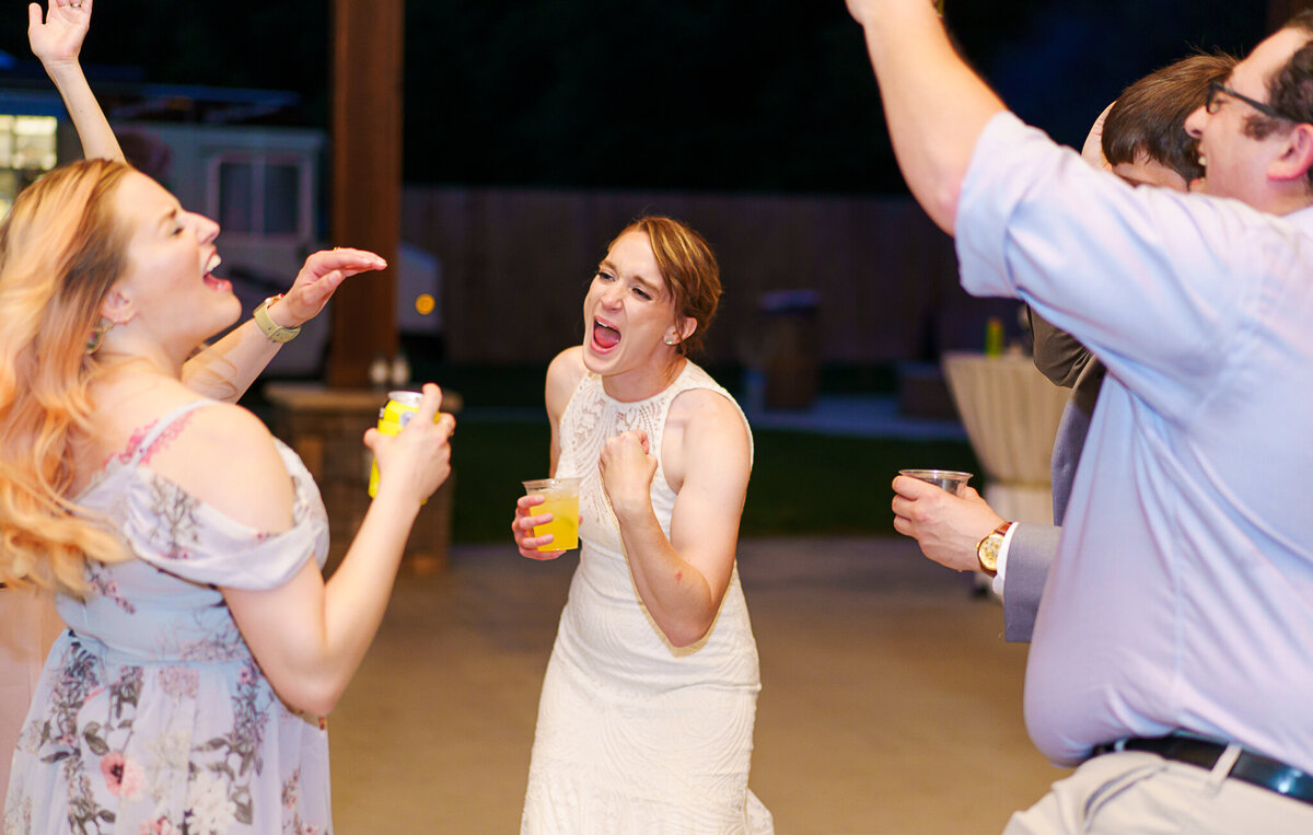 The bride, Liz, sings enthusiastically as her friends laugh and dance around her at her wedding reception at Four Seasons Barn in Cardington, Ohio.