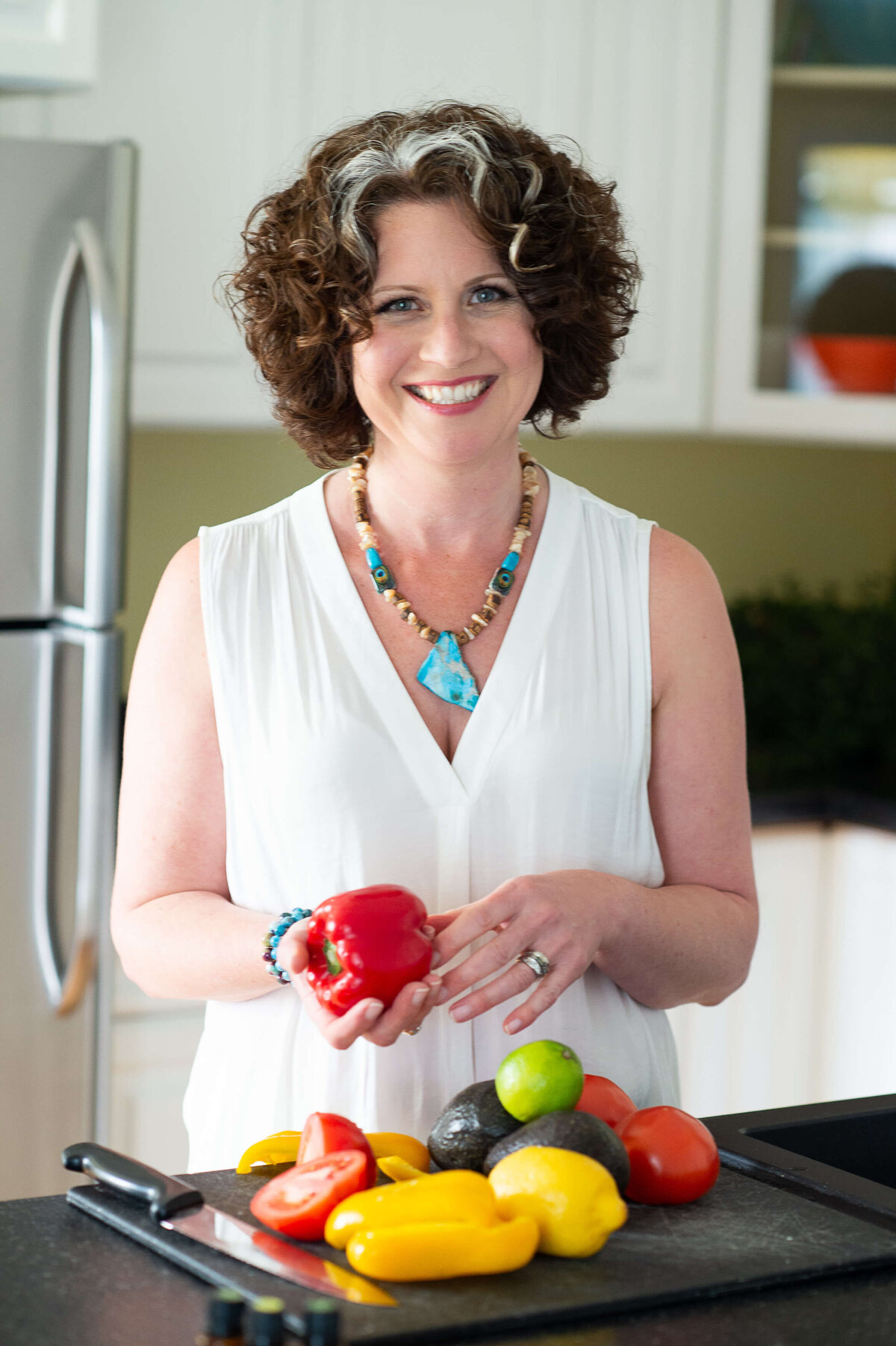 a photo of a dietician in the kitchen with colour vegetables and a cutting board.  Captured by Ottawa Branding Photographer JEMMAN Photography COMMERCIAL