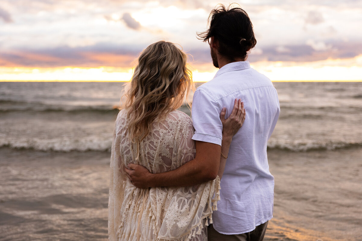 couple standing by the water during a syracuse maternity session