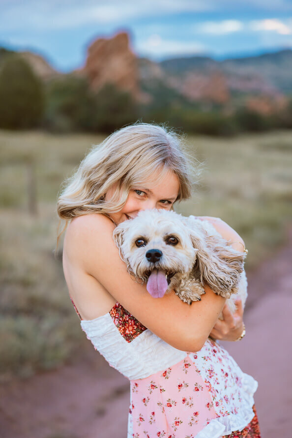 Girl snuggles her puppy for her senior session.