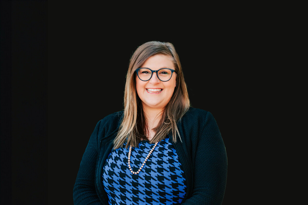 Branson Missouri professional headshot captures woman smiling against black background