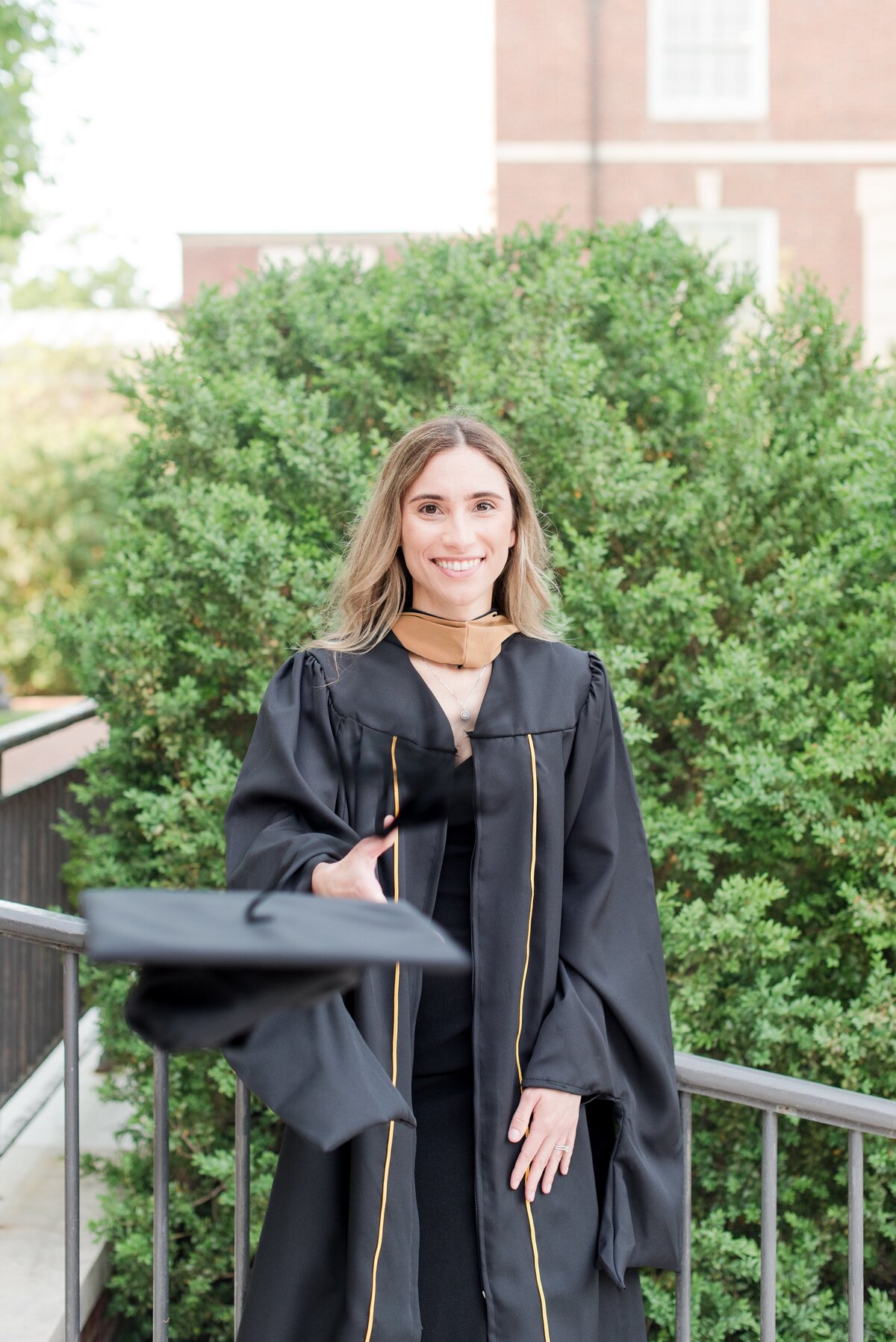 graduate throwing cap at gilman hall jhu
