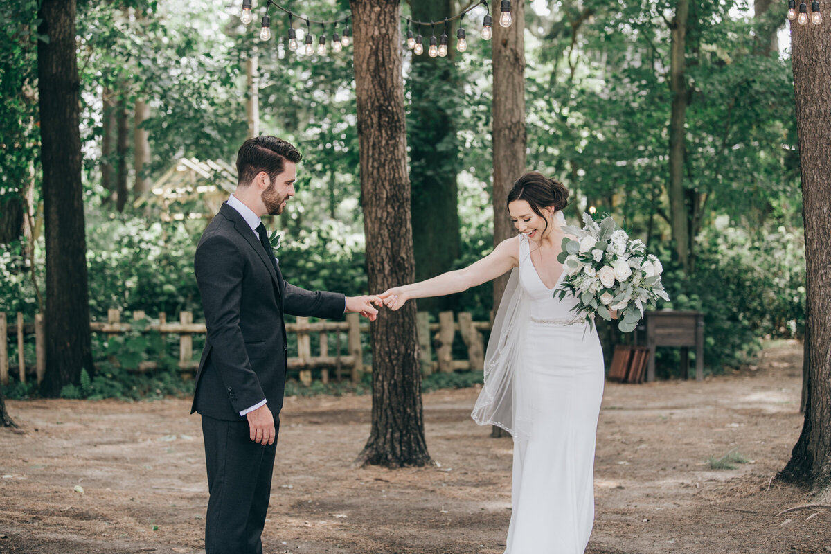 A wedding day first look between a bride and groom in an enchanted forest