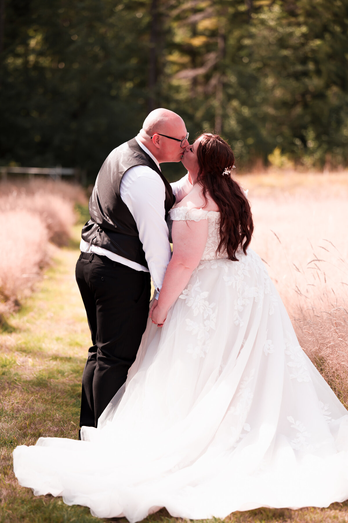 plus size bride and groom kissing on a pathway through wheat field at the Vancouver Island Wedding