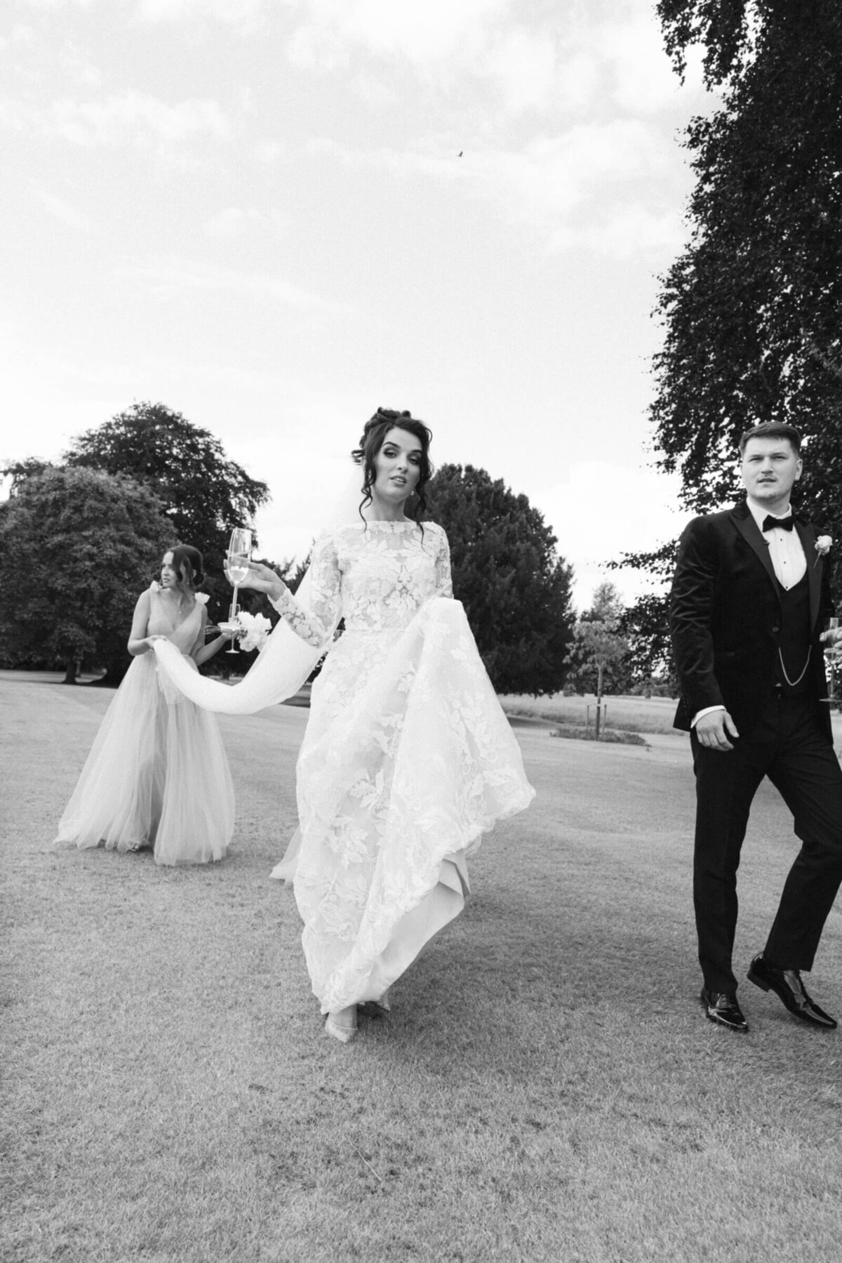 A black and white photo of the bride and groom walking together in the gardens of Luttrellstown Castle