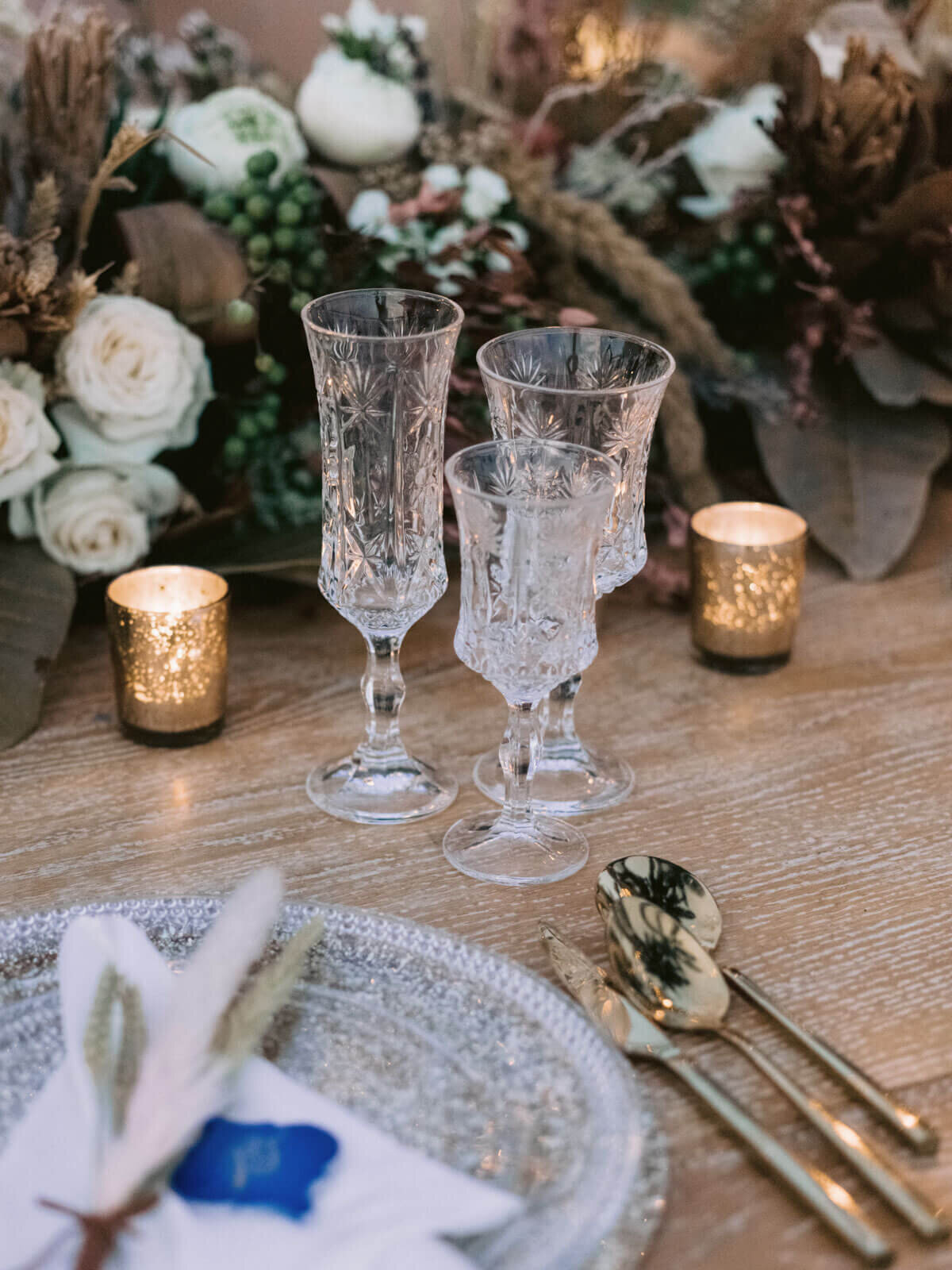 Elegant plate, cutleries, and wine glasses on a table with pretty flowers in Khayangan Estate, Indonesia. Image by Jenny Fu Studio