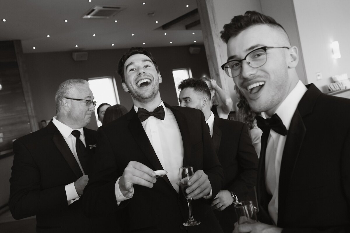 Wedding guests enjoying oysters and big laughs in their luxury suits