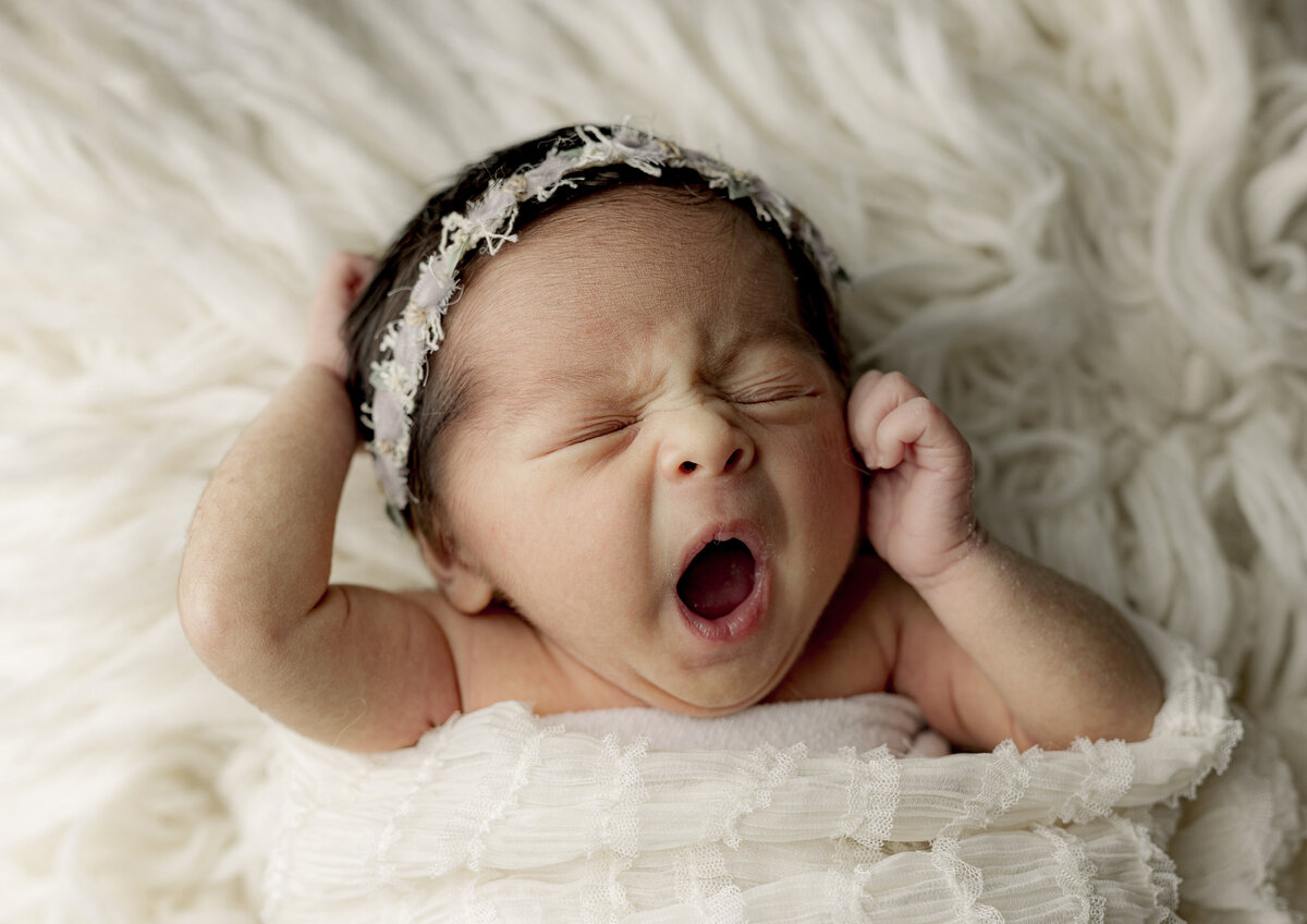 baby girl yawning on flokati cream rug
