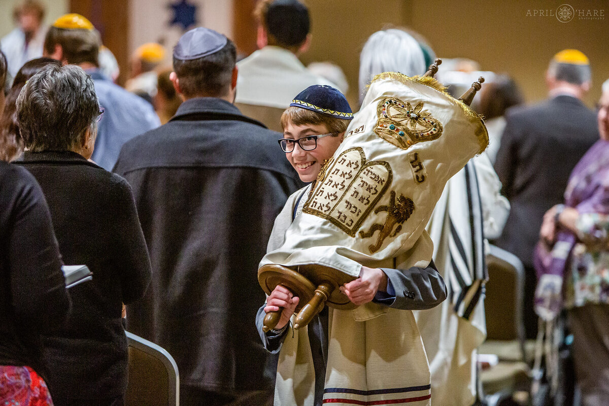 Colorado Bar Mitzvah Photographer photographs a boy carrying the Torah at his service in Fort Collins