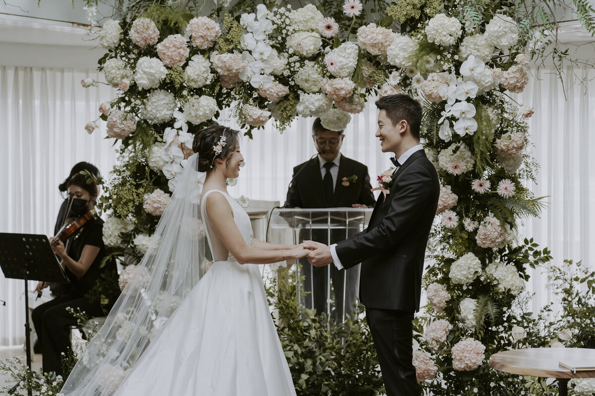 the couple holding each others' hands at the altar in the ailey house on han river in seoul