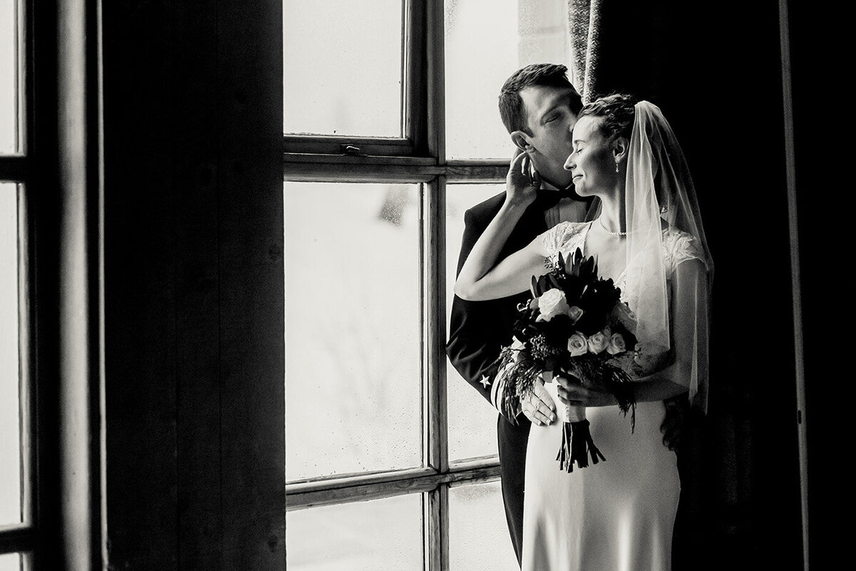 bride and groom by window