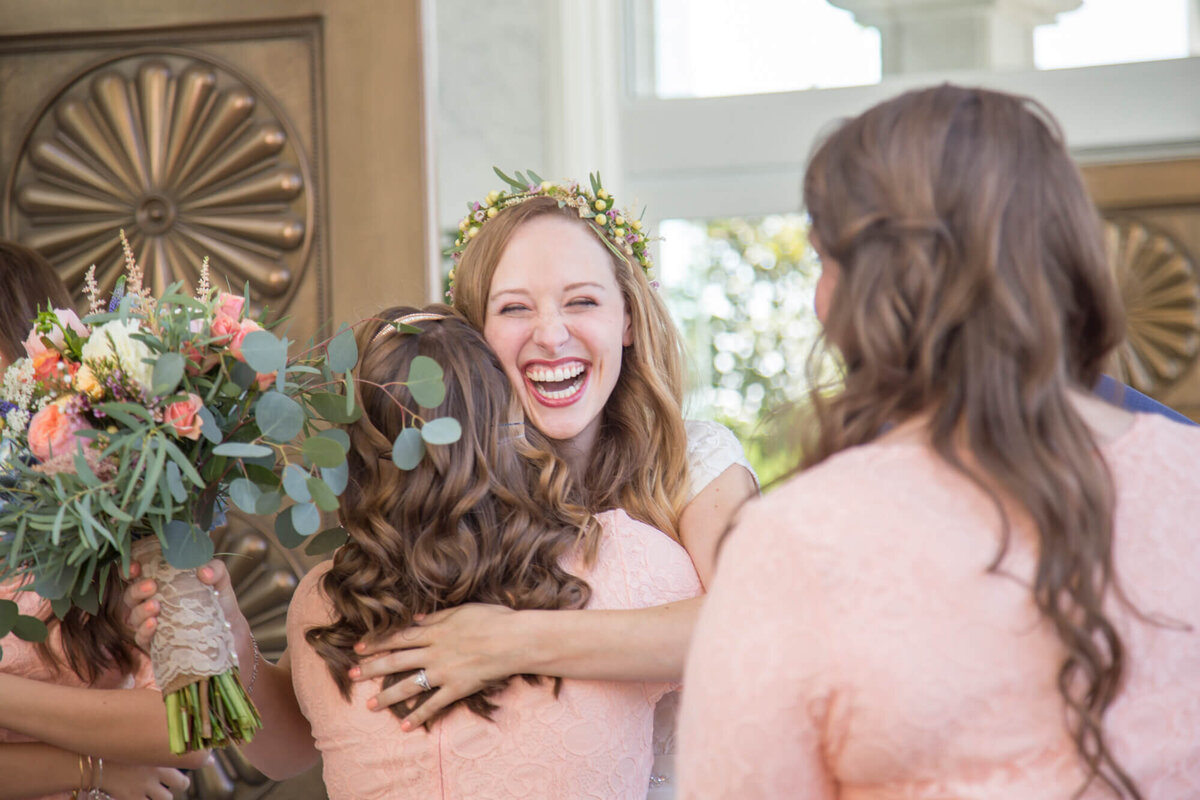 stunningly happy bride hugs bridesmaid after lds temple wedding ceremony