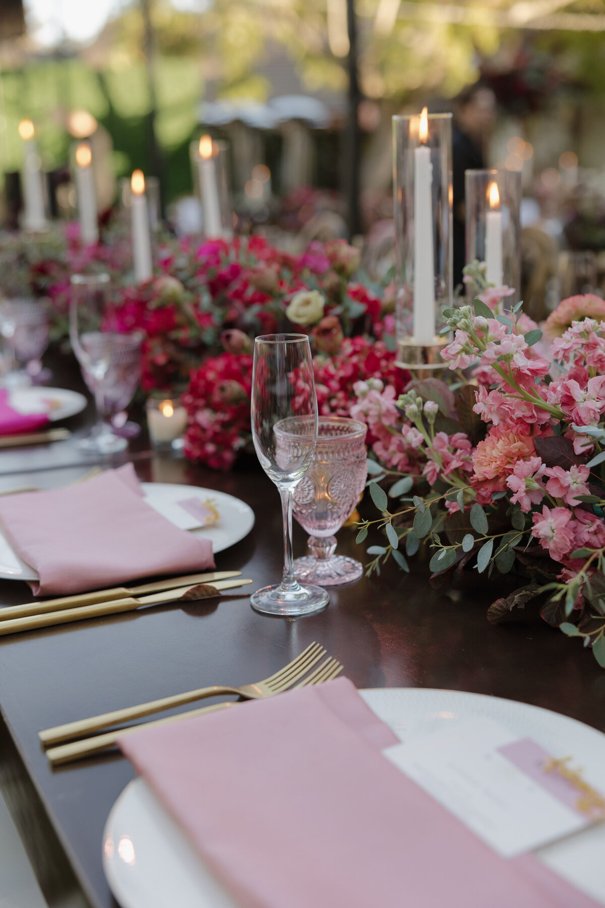 Stunning pink ombre details and flowers on a long style table at a wedding reception.