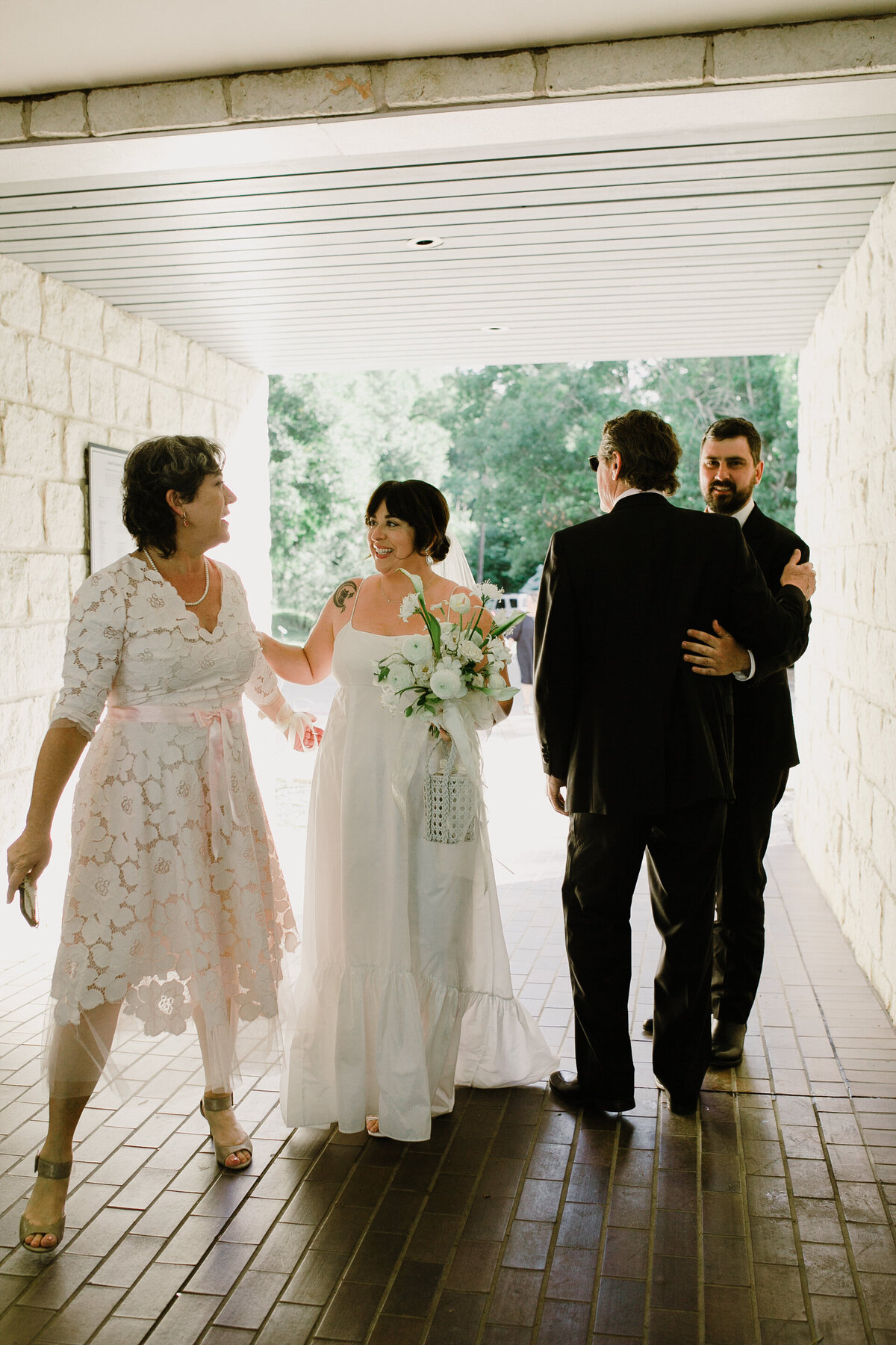 Bride walking under covered walkway at Umlauf Sculpture Garden Wedding, Austin