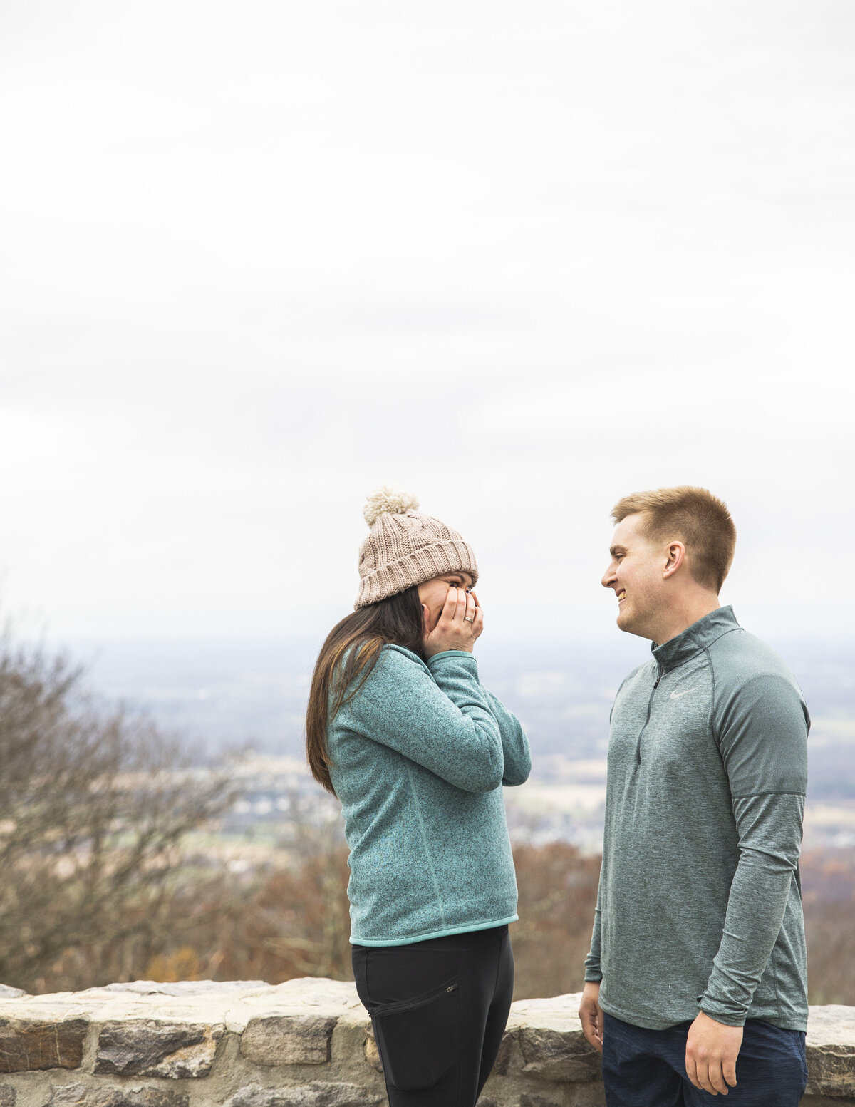 A couple smiles happily at one another at their Maryland proposal.