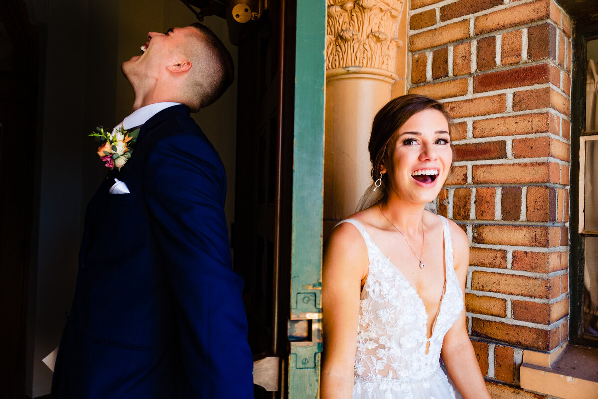 One of the top wedding photos of 2020. Taken by Adore Wedding Photography- Toledo, Ohio Wedding Photographers. This photo is of a bride and groom first look laughing and holding hands