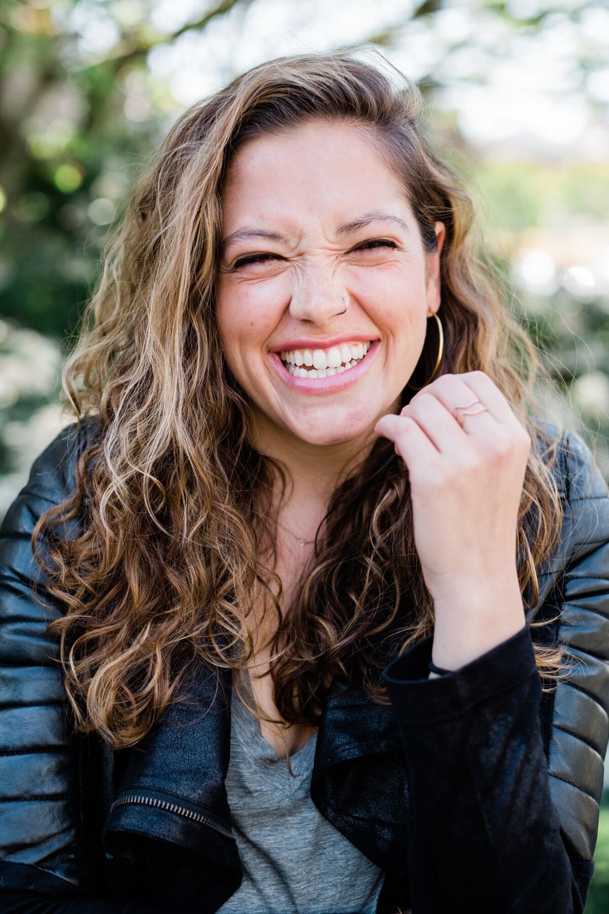 A woman smiling while wearing a black jacket in Seattle.