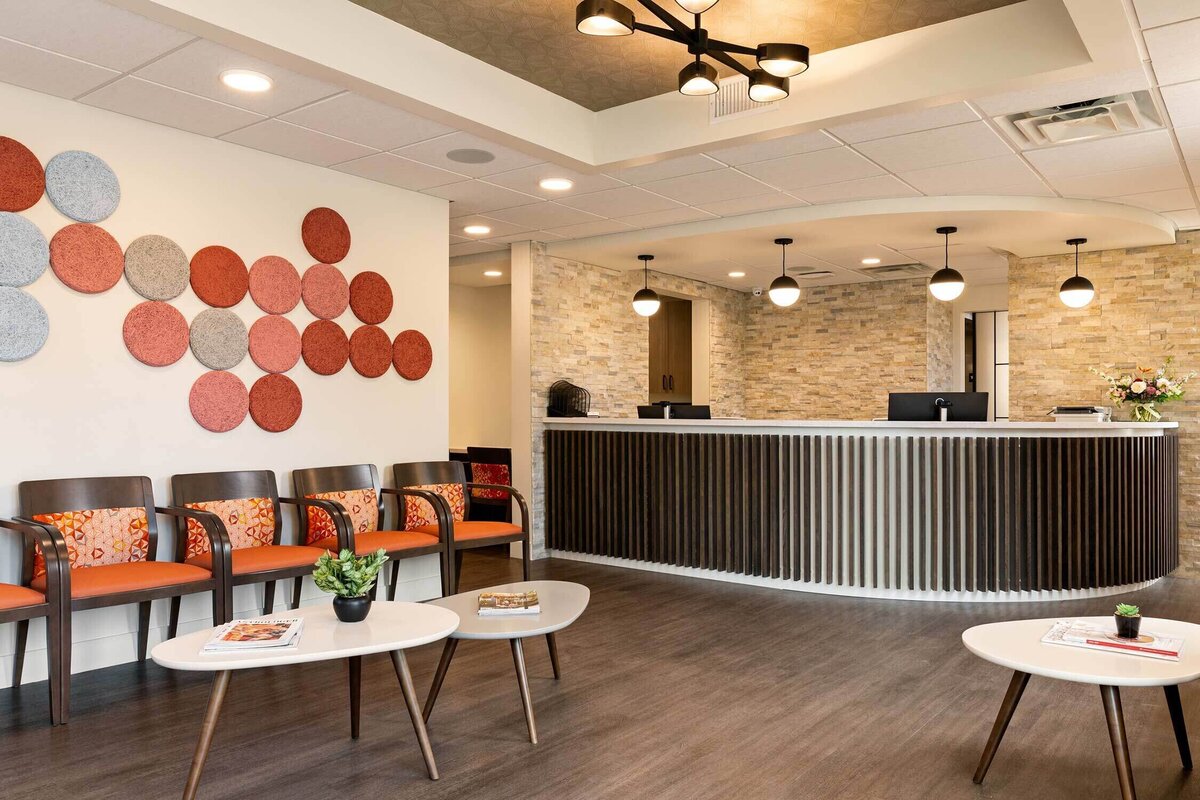Mid Century Modern inspired dental office lobby with fluted wood reception desk and playful patterns