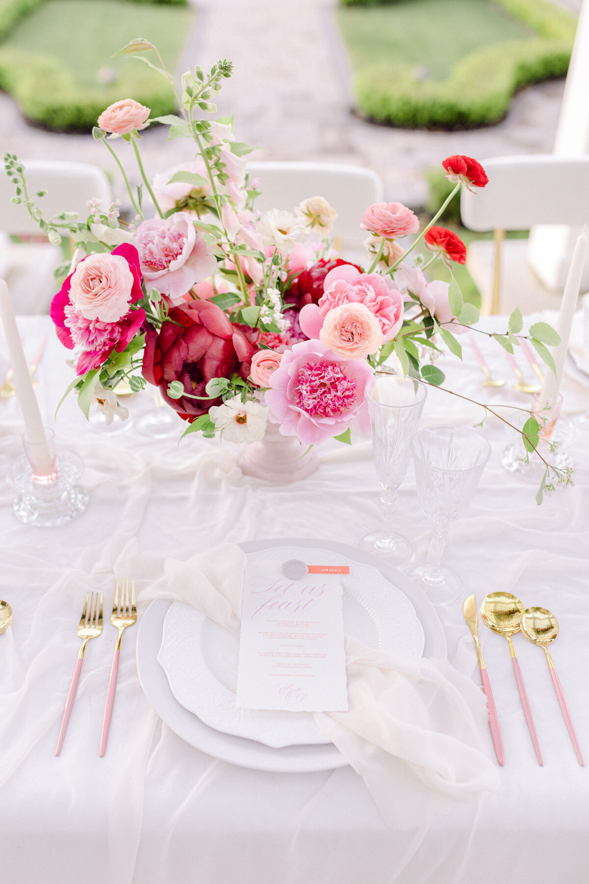 Pink and red peonies and lush flowers in a centrepiece at a Stonehaven wedding reception.