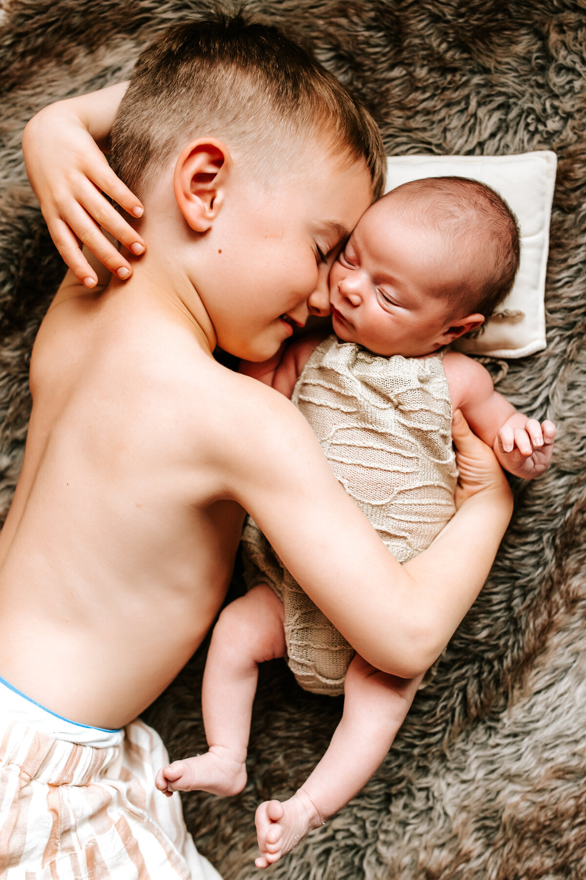 Big brother cuddling baby at Ottawa Newborn Photography session