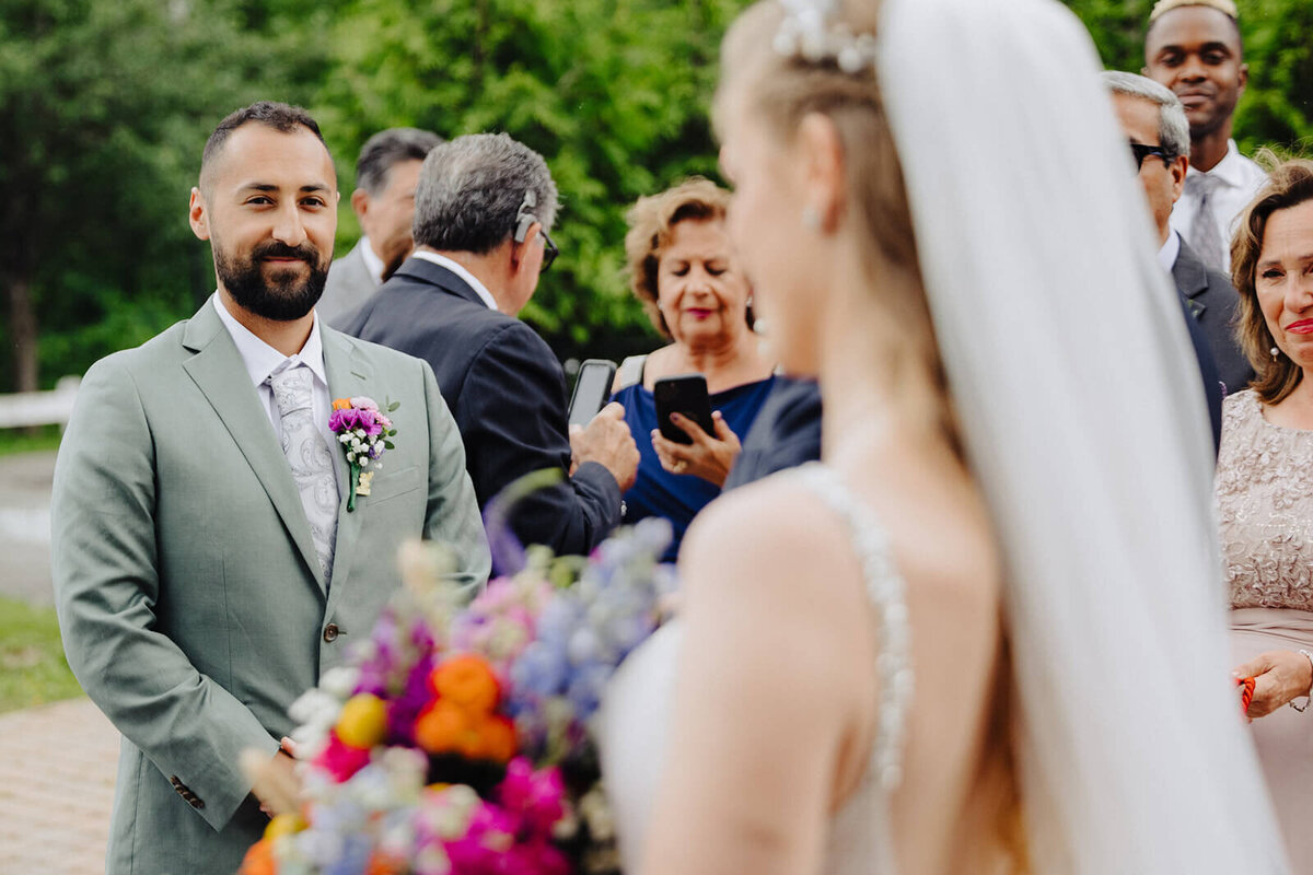 Bride looking at groom at wedding ceremony at The Mansion at Keuka Lake, NY