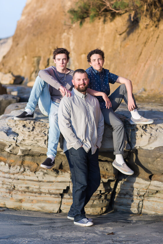 father-and-sons-sitting-on-rocks-Scripps-Pier-San-Diego