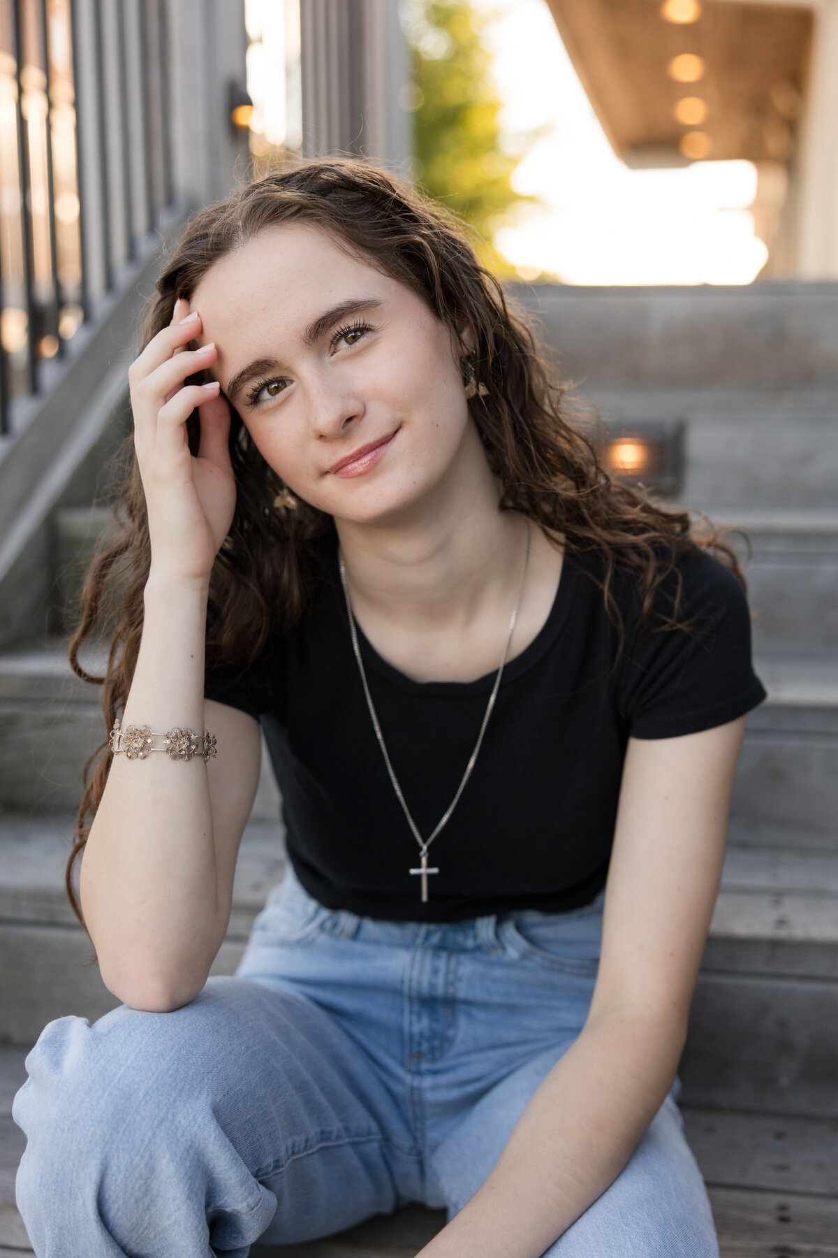 Senior girl seated on a staircase smiling at the camera