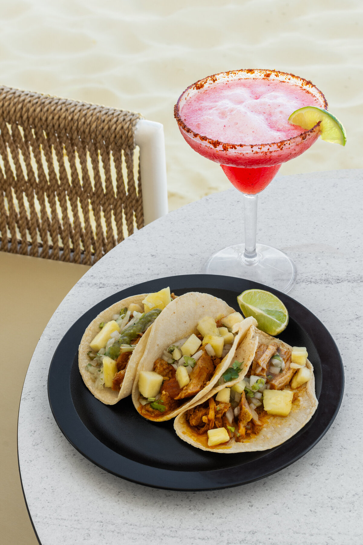 A frozen spicy strawberry margarita and a plate of three pork and pineapple tacos photographed at the Tequila Bar on the Riu Latino Hotel property in Cancun, Mexico.