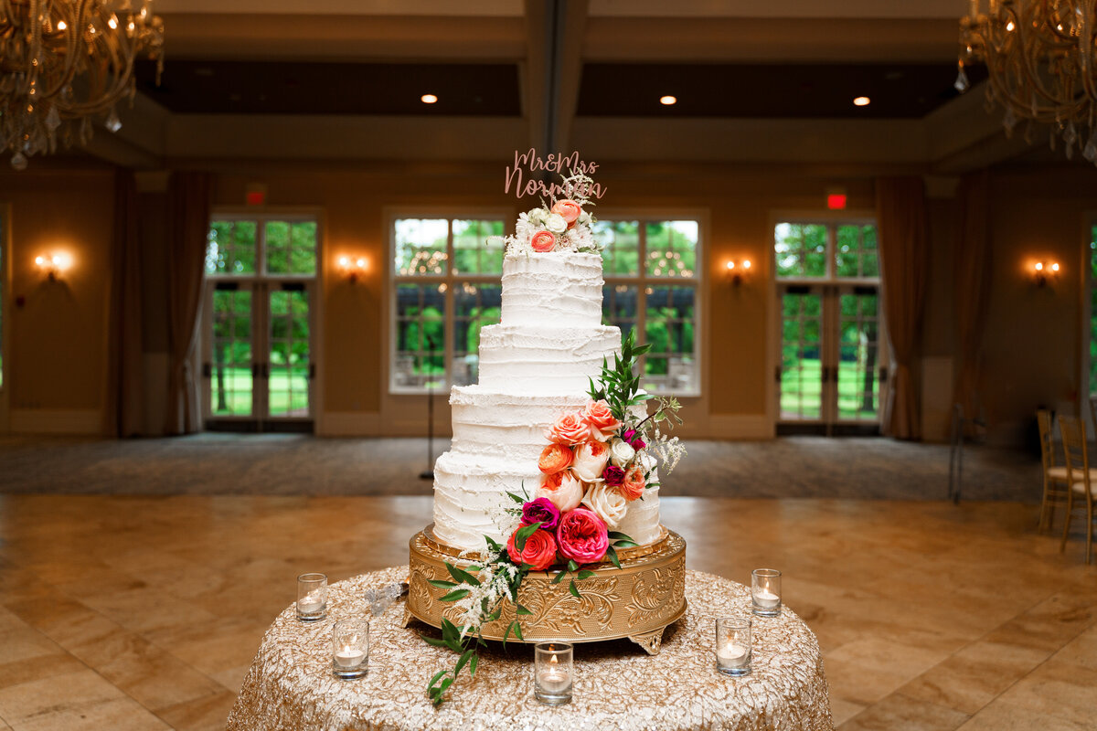 Beautiful 4 tier wedding cake with colorful flowers cascading down at The Pinnacle Golf Course in Grove City, Ohio.