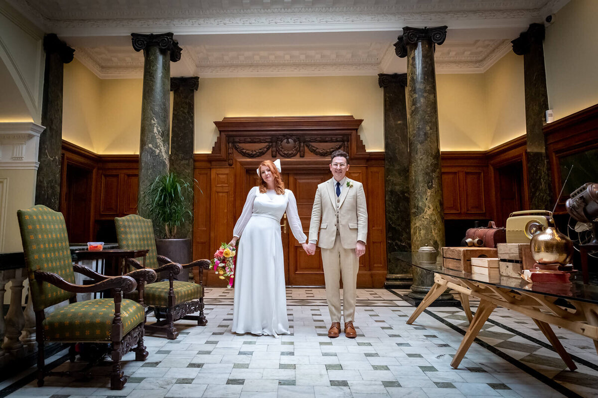 Bride and groom holding hands in Town Hall Hotel London