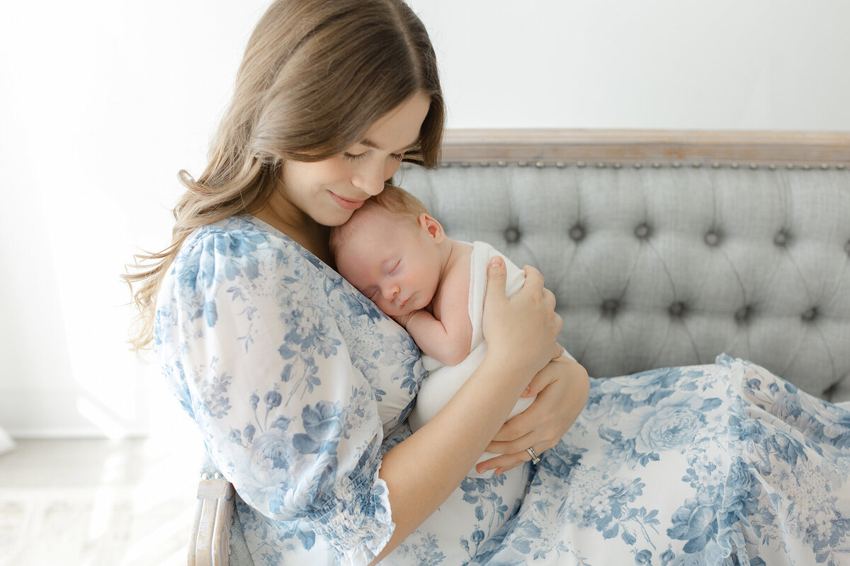 half swaddled baby sleeping on mom's chest. by main line newborn photographer