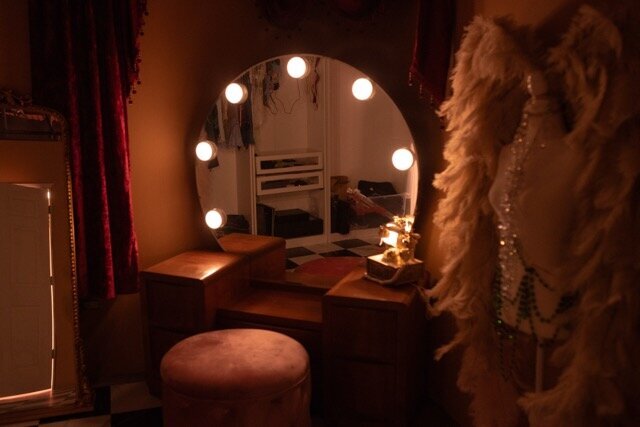 Old Hollywood burlesque dressing room style boudoir set with dramatic lighting, mirror glow, and luxe red velvet styling at Bri Valiente Boudoir studio in Chicago.
