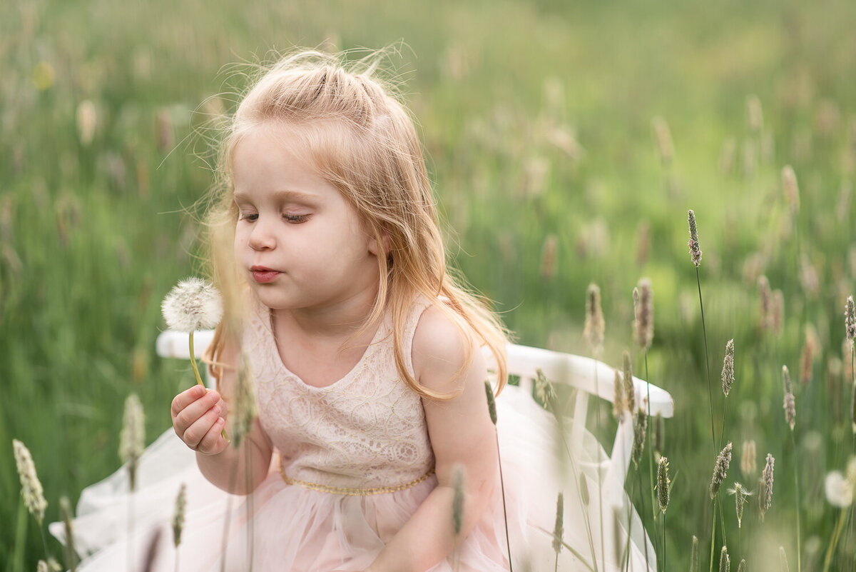 Little girl blowing dandelion in field at sunset for family photo shoot |Sharon Leger Photography | Canton, CT Newborn & Family Photographer