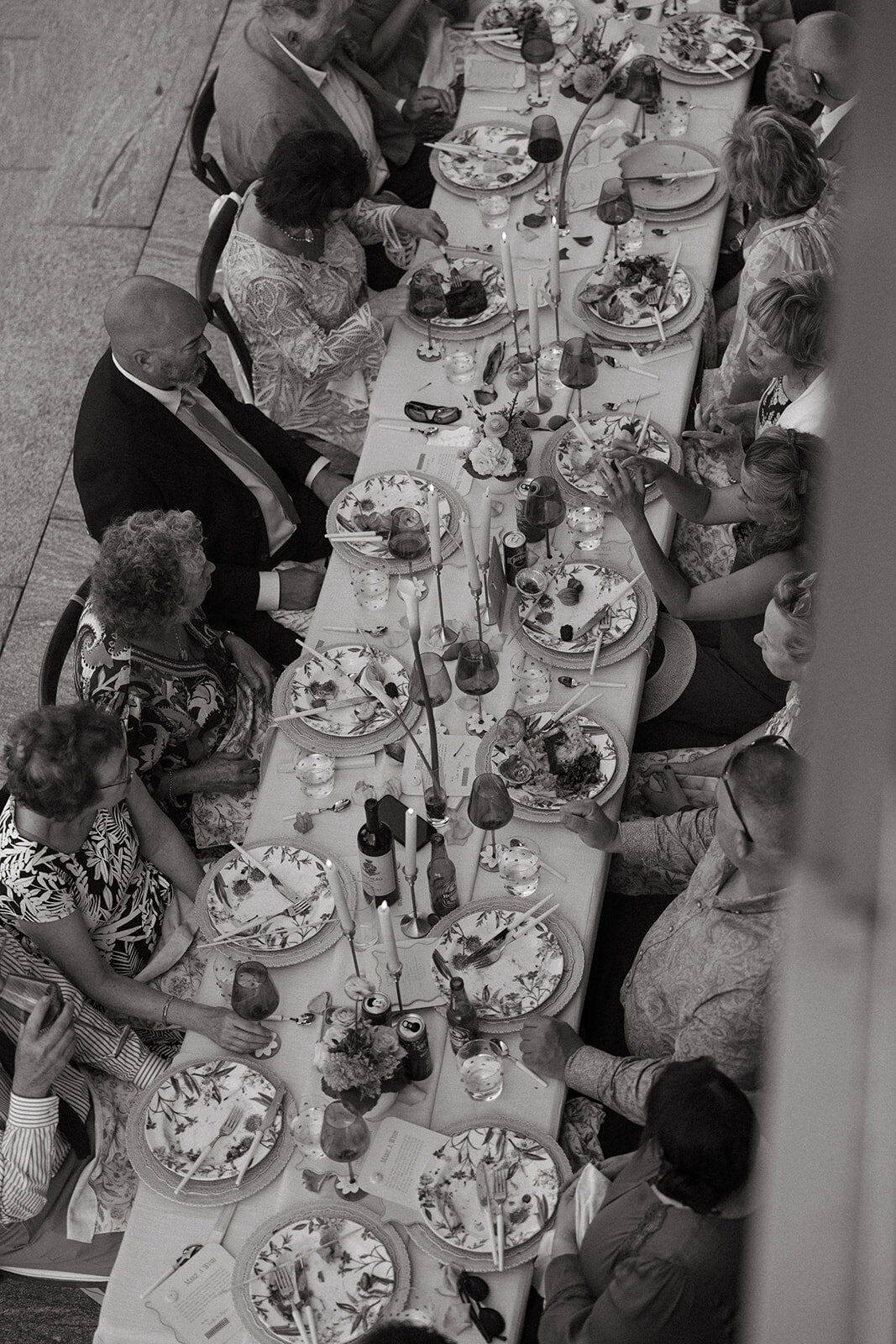 overhead black and white shot of wedding table with guests eating